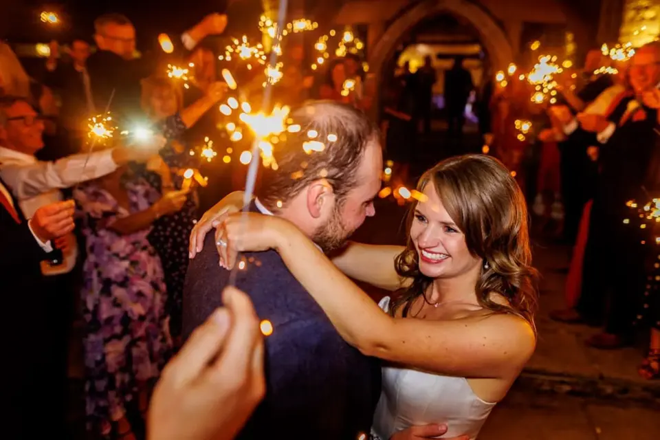 A wedding guest laughing with a newly married couple