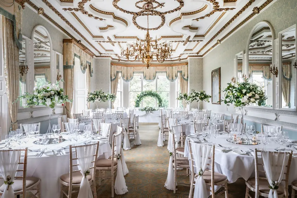 An elegant wedding room styled with white flowers and table decorations