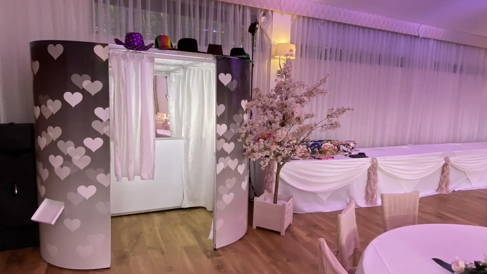 Limelite enclosed Photobooth in the Hearts skin, set up beside the prop table